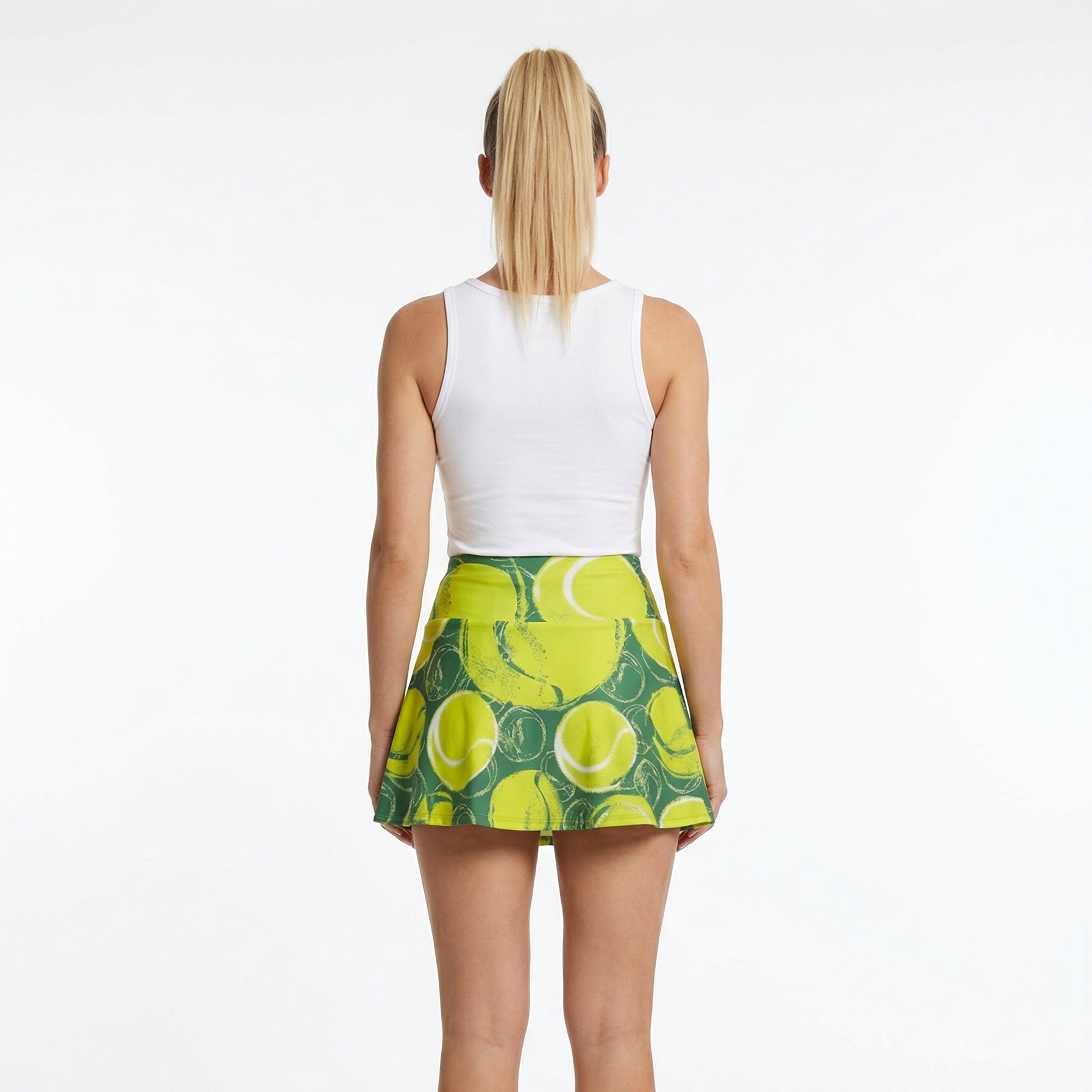 Person wearing a white sleeveless top and green tennis skirt with yellow patterns on a white background