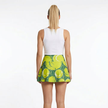 Person wearing a white sleeveless top and green tennis skirt with yellow patterns on a white background