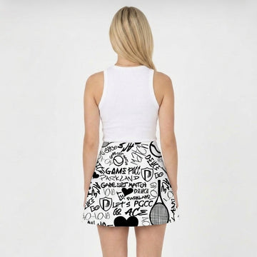Woman wearing a white sleeveless top and black and white patterned skirt on a white background