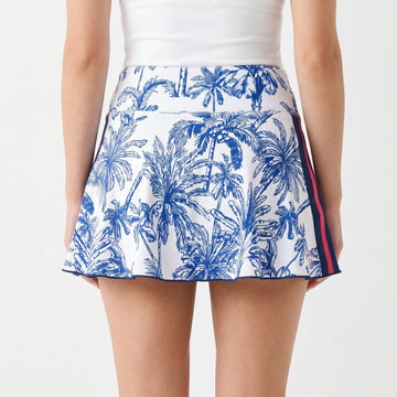 Blue and white patterned skirt worn by a person on a light gray background