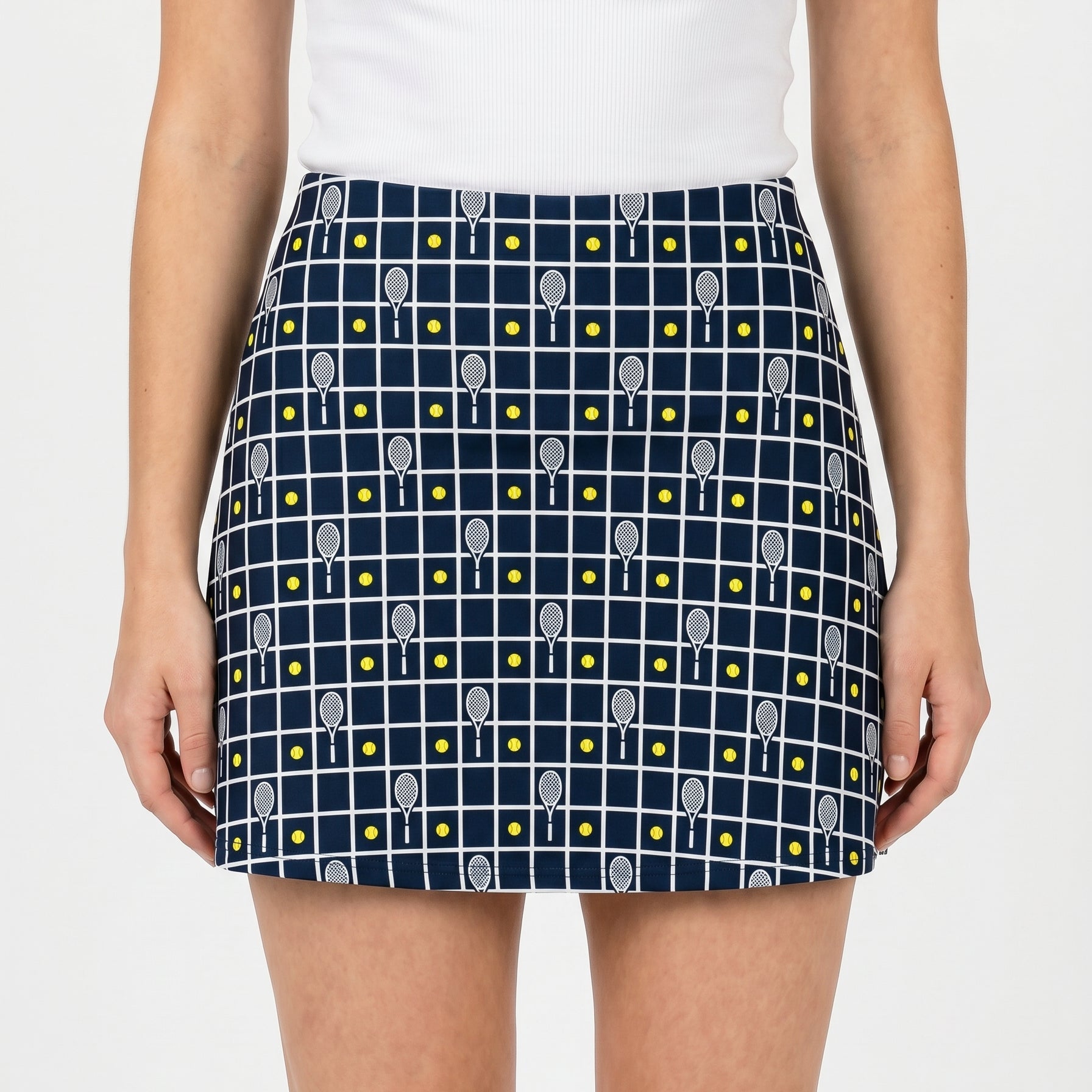 Navy blue skirt with tennis racket pattern worn by a person on a white background