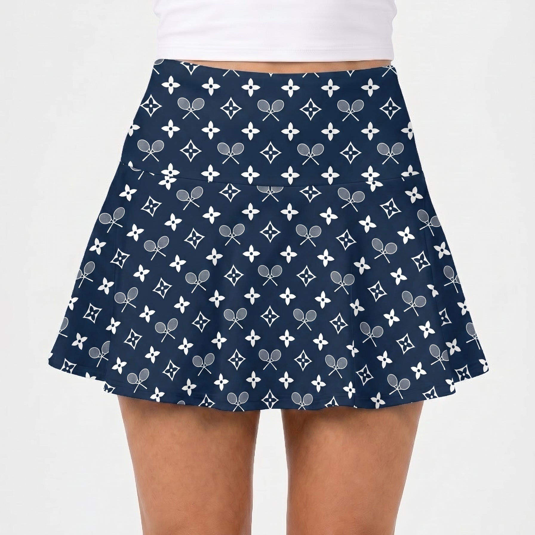 Navy blue skirt with tennis racket pattern worn by a person on a white background