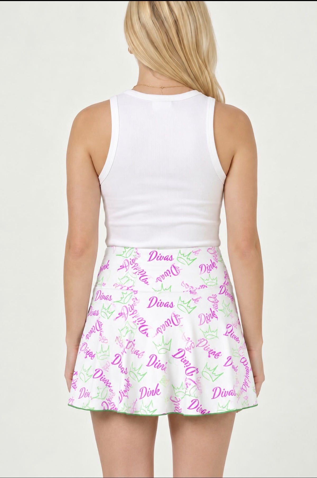 a woman in a white tank top and a white skirt with purple and green text