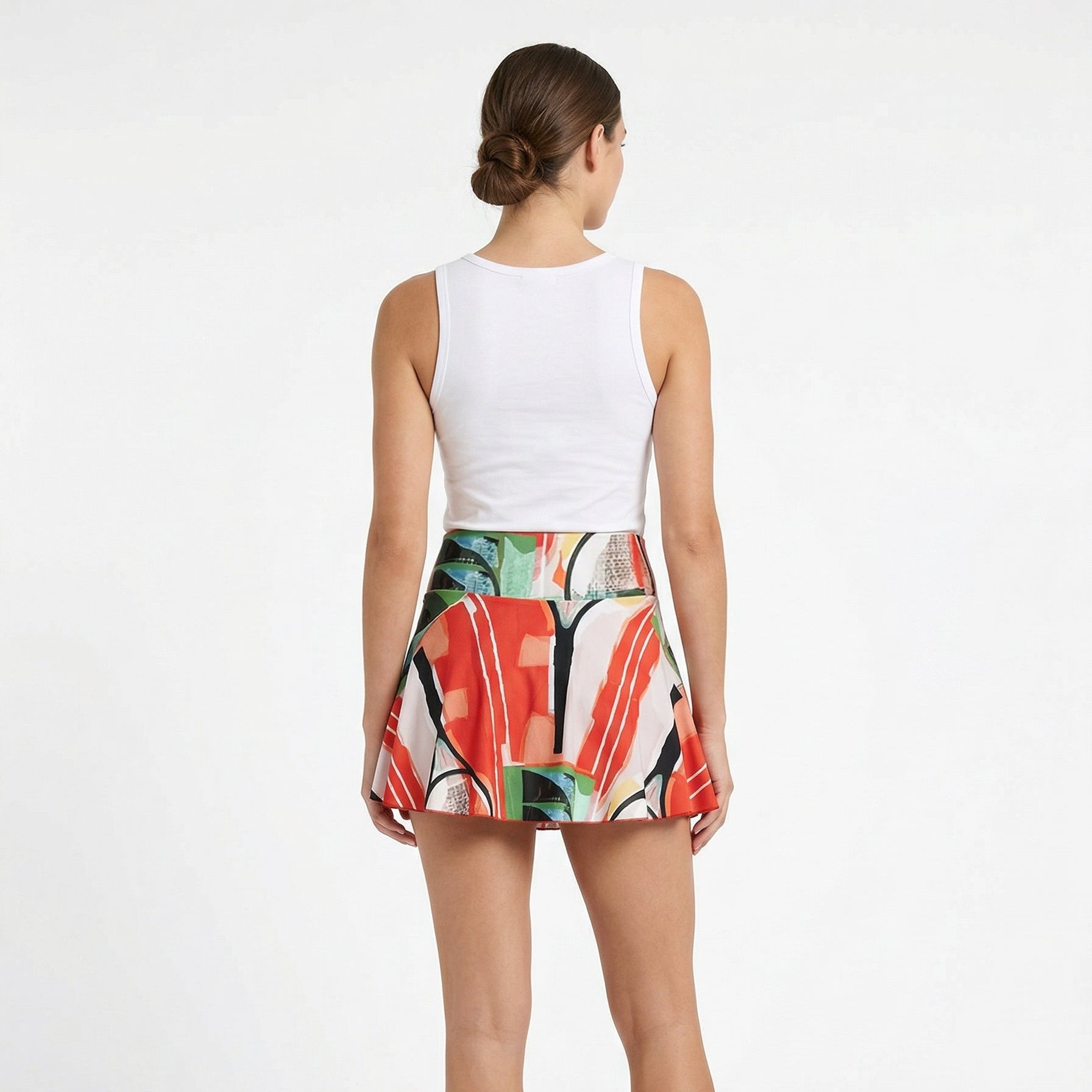 Woman wearing a colorful skirt with a white top on a white background