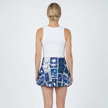 Woman wearing a white top and blue patterned skirt on a white background